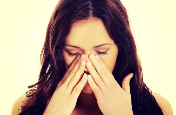 Young woman with sinus pain.